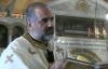 Priest standing inside a church, holding relic.