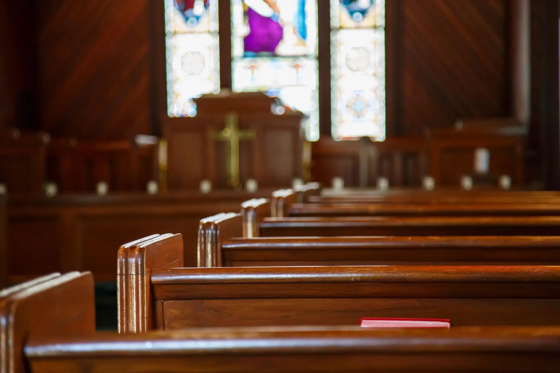 Empty wooden pews in a church interior.