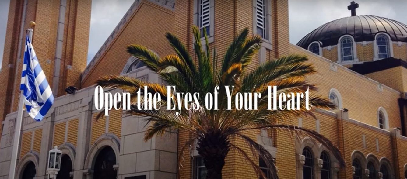 Church exterior with palm tree and flag.