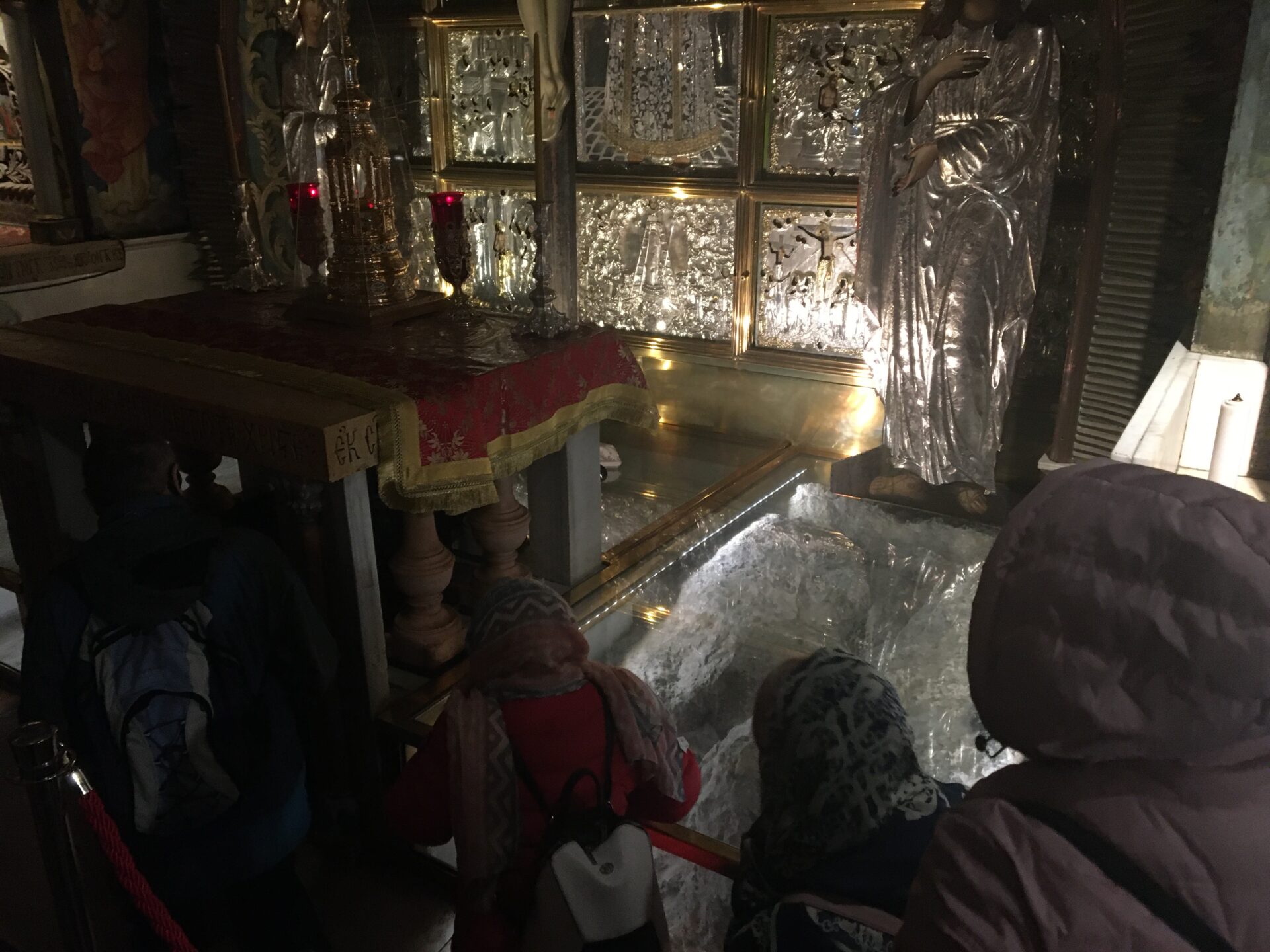 People visiting a dimly lit religious site.