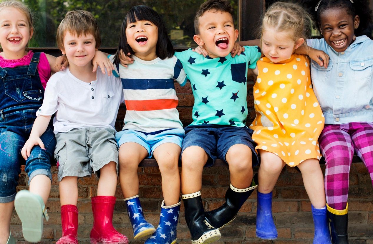 children putting hands on each other shoulder