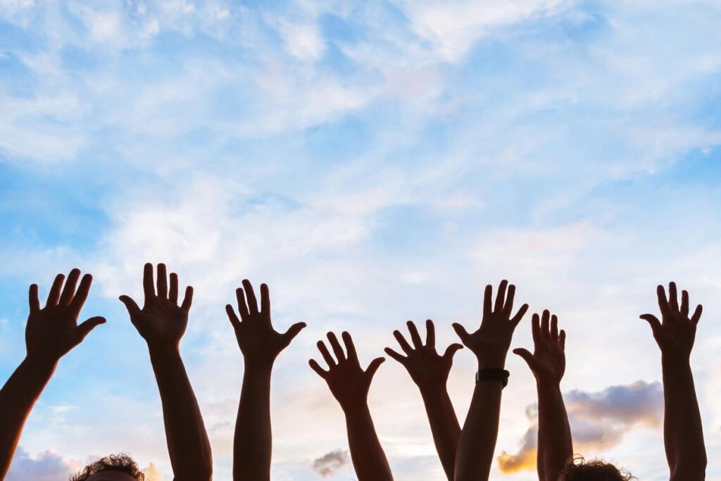 A group of men raising their hands together in the air