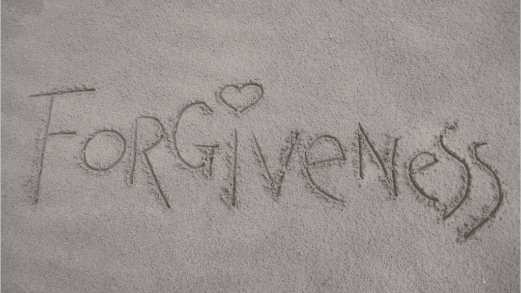 Forgiveness engraved on wet sand