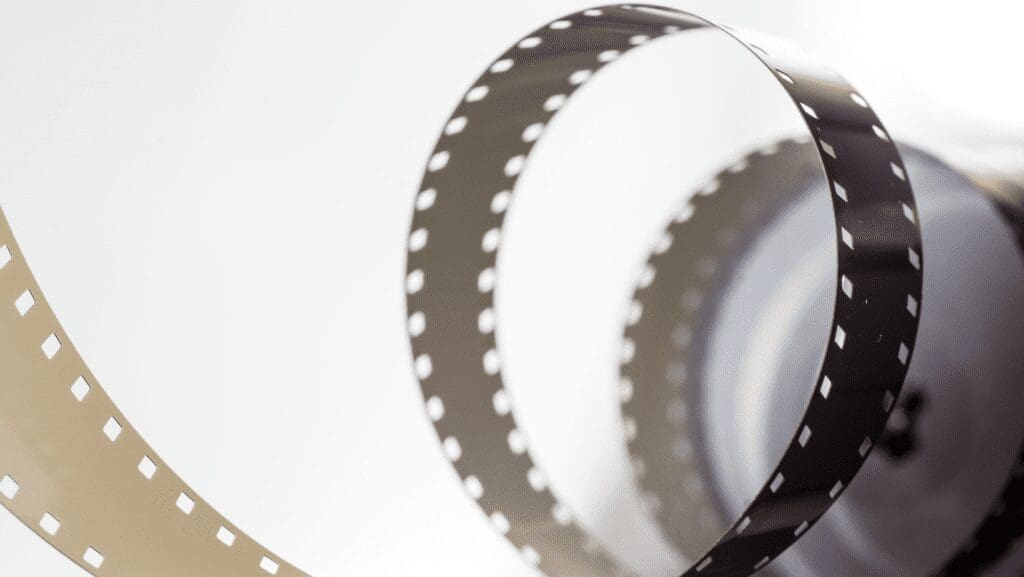 Curved photographic film strip on white background.