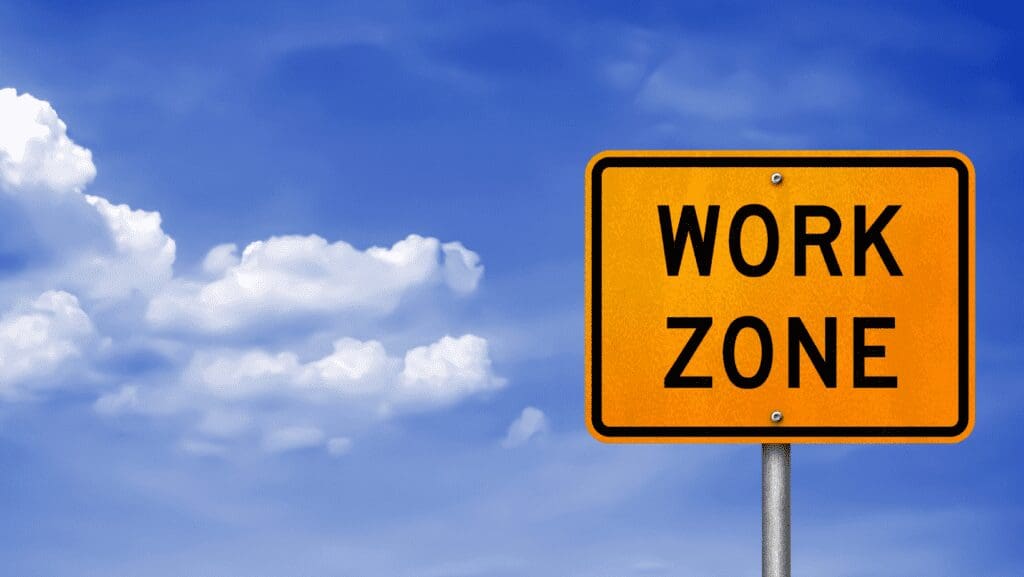 Work Zone sign under blue sky.