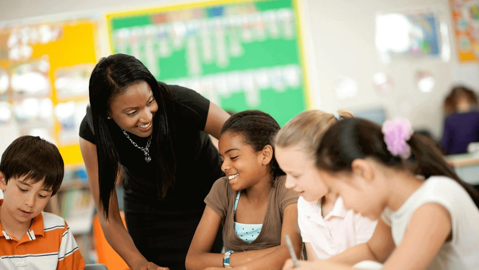 Teacher helping students in a classroom.