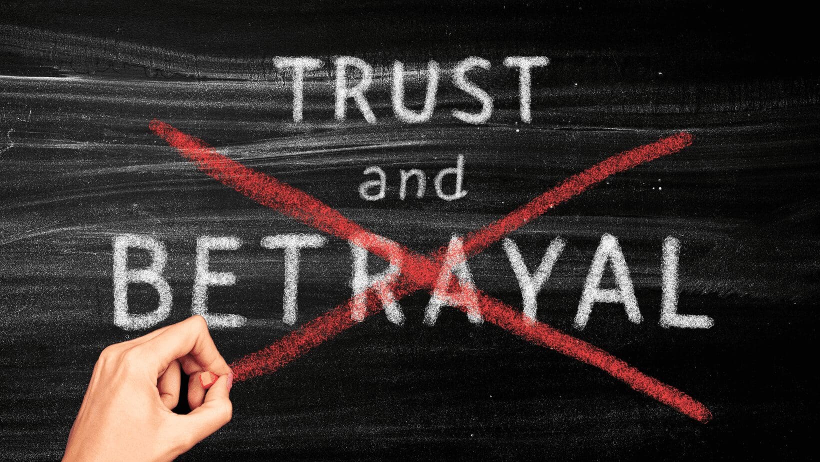 Trust and betrayal crossed out on chalkboard.
