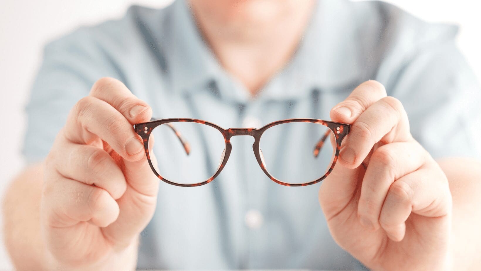 A man handing eyeglasses