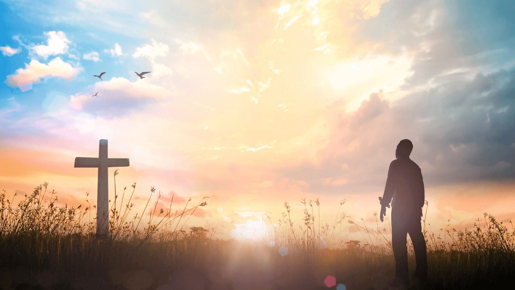 A man approaching a cross during sunrise