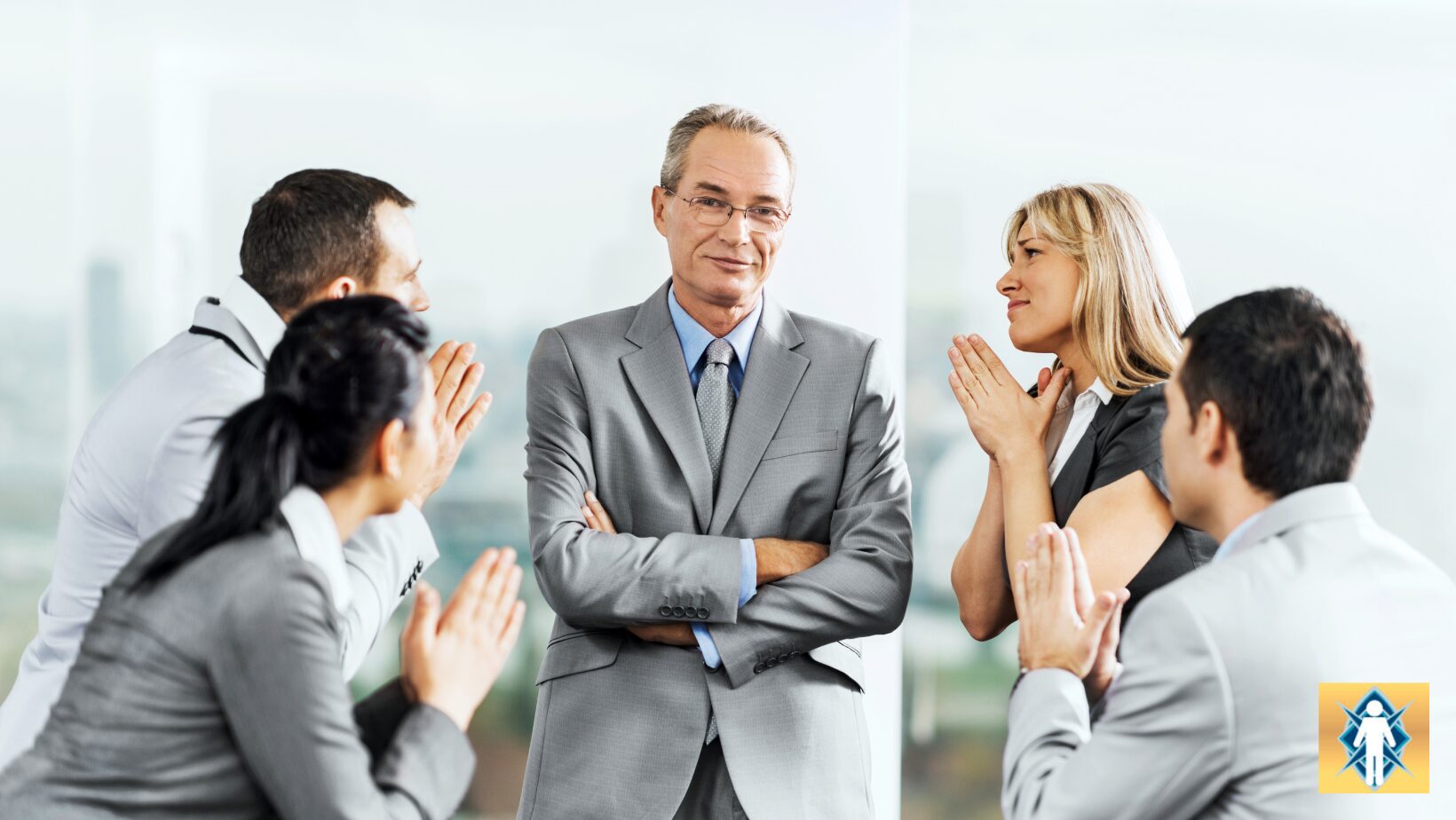A confident businessman stands as colleagues applaud him.