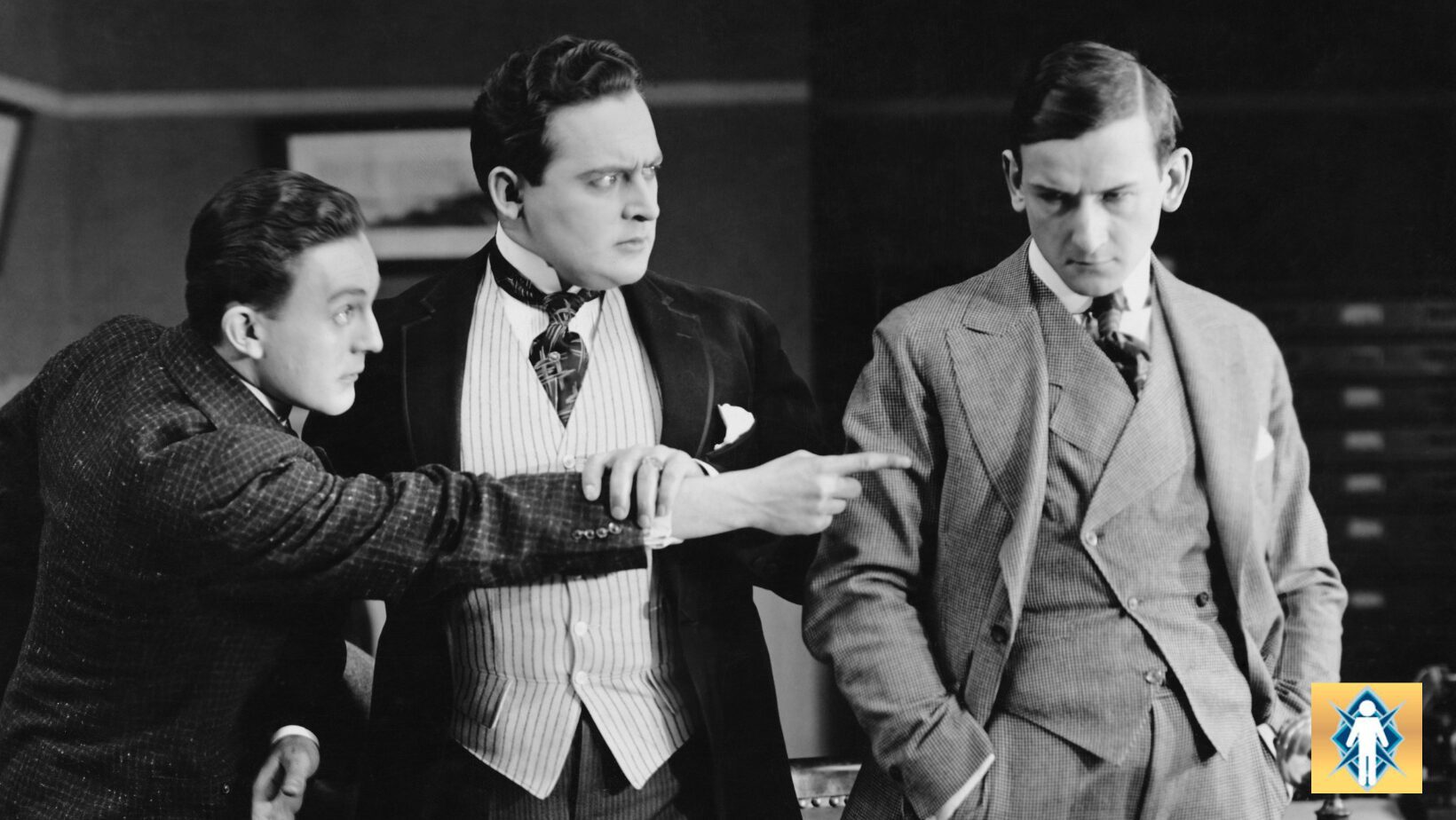 Three men in vintage attire engaged in a serious conversation indoors.