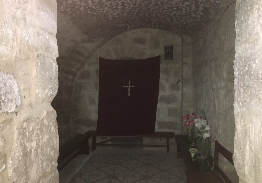 Stone room with cross and flowers.