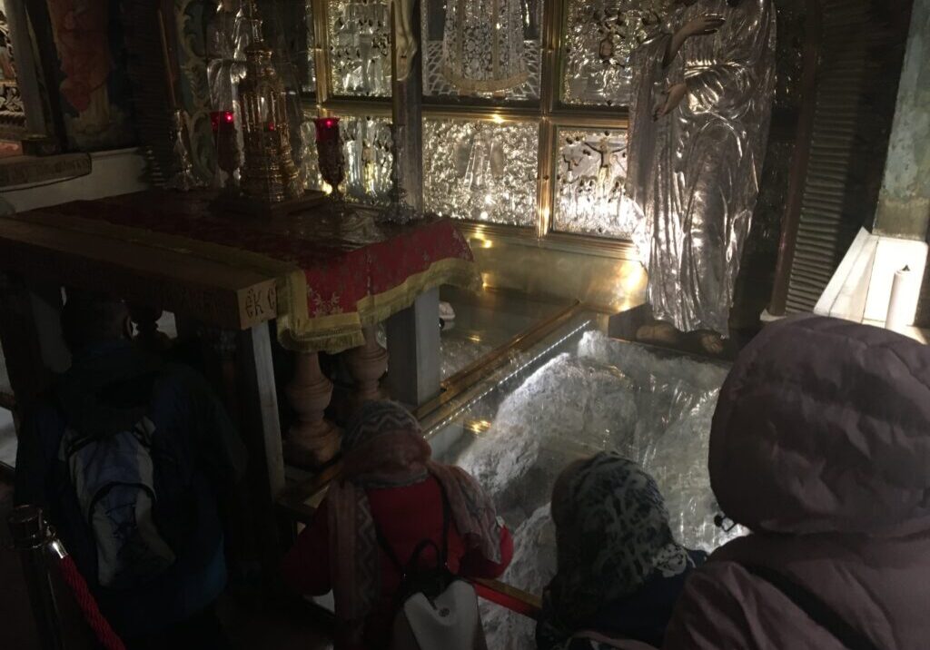 People visiting a dimly lit religious site.