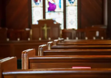 Church pews with stained glass background.