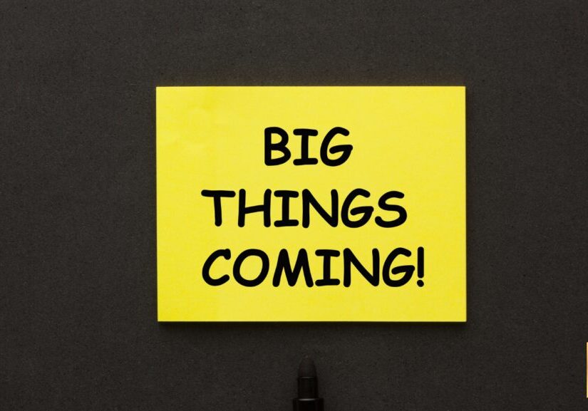 Yellow sticky note with 'BIG THINGS COMING!' message on black background.