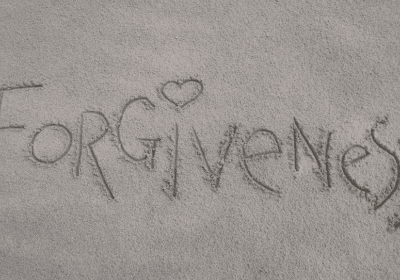 Forgiveness engraved on wet sand