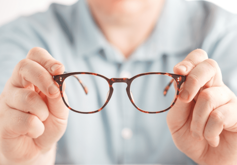 A man handing eyeglasses