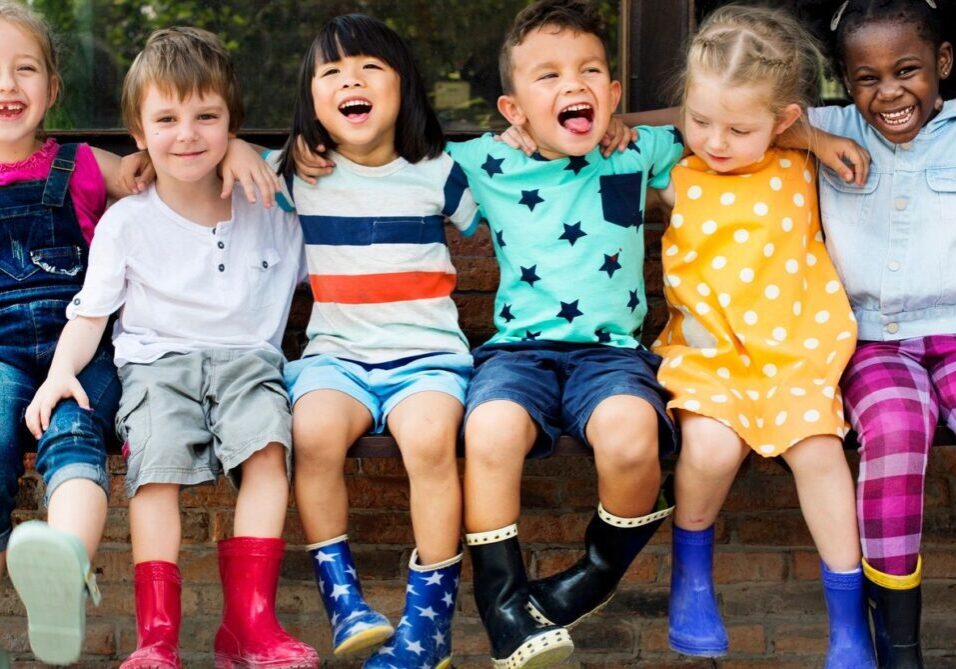 children putting hands on each other shoulder