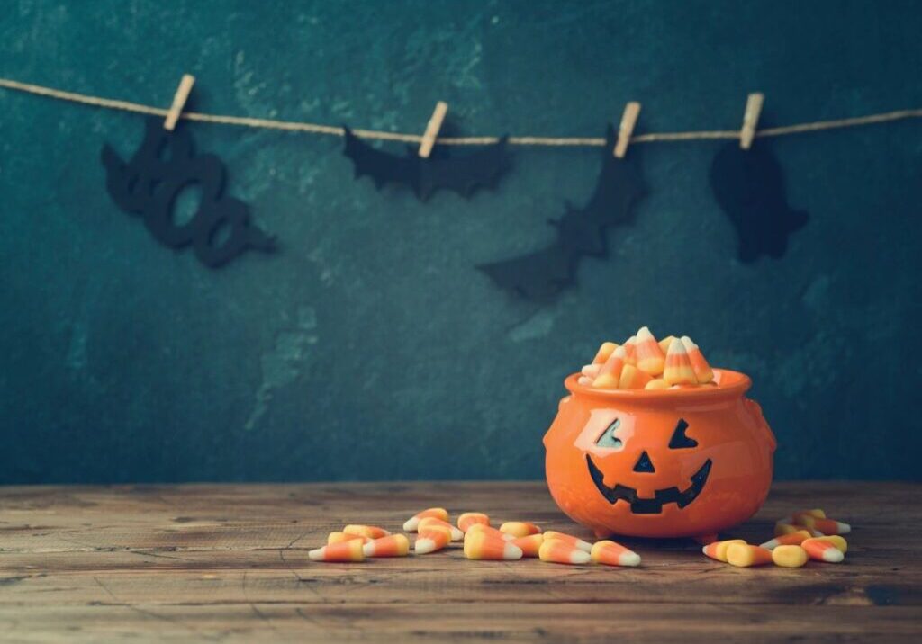 A pumpkin shaped bowl filled with candies