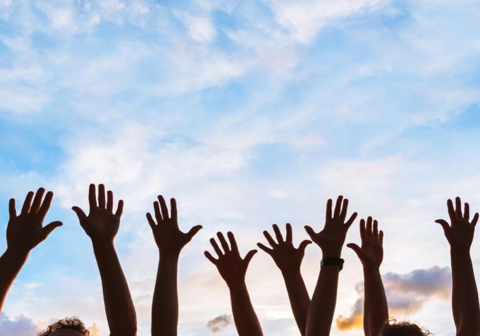 A group of men raising their hands together in the air