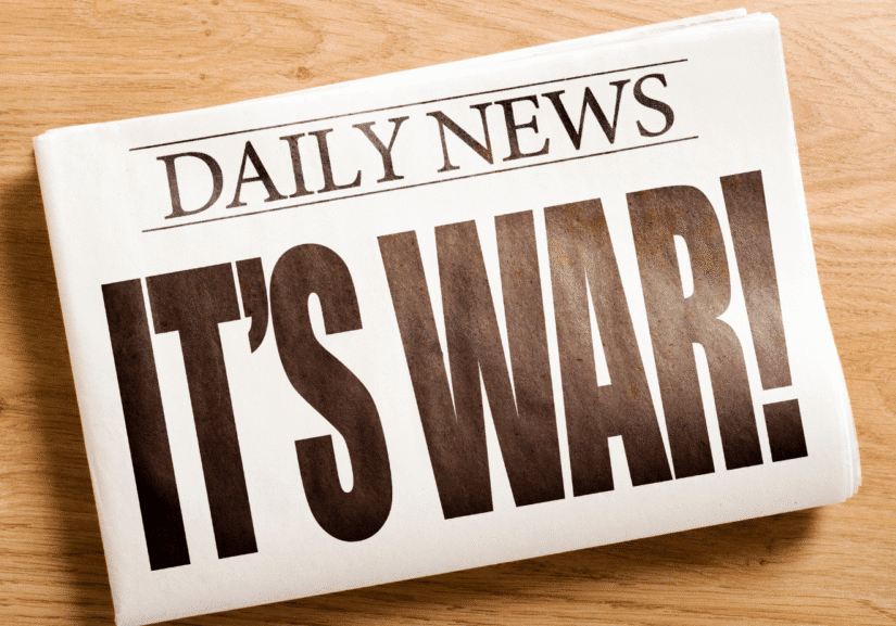 Newspaper headline: "It's War!" on table.